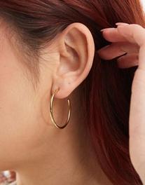 Oferta de ASOS DESIGN waterproof stainless steel hoop earrings with skinny detail in gold tone por $12 en ASOS