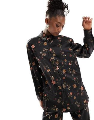 Oferta de AllSaints Louisa Tanana satin shirt in floral black por $64 en ASOS