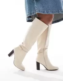 Oferta de Yours knee high heeled boots in off white por $87.99 en ASOS