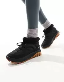 Oferta de Columbia Snowtrot shorty snow boots in black and sea salt por $90 en ASOS