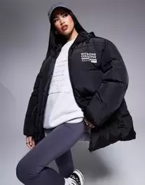 Oferta de Weekend Collective waisted padded coat with logo in black por $64 en ASOS