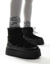 Oferta de South Beach Borg Lace Up Platform Mini Boot in Black por $56.5 en ASOS