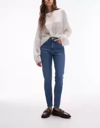 Oferta de Topshop high rise Jamie jeans in mid blue por $56.99 en ASOS