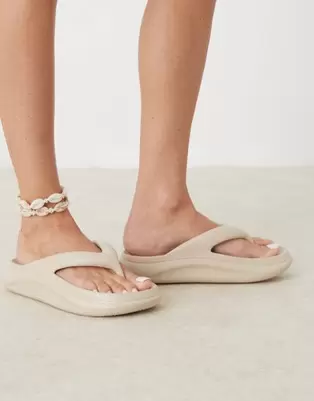 Oferta de ASOS DESIGN Fudge chunky flip flops sliders in beige por $14 en ASOS