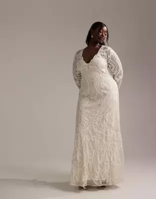 Oferta de ASOS DESIGN Curve embroidered plunge long sleeve maxi wedding dress in ivory por $280 en ASOS
