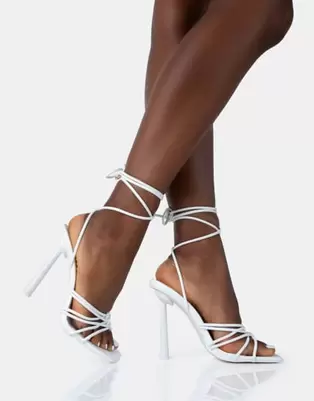 Oferta de Public Desire Glow up pu knotted strappy lace up square toe stiletto heels in white pu por $18 en ASOS