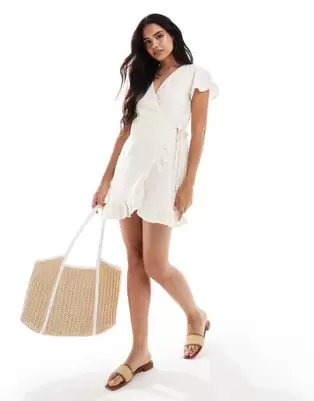 Oferta de Vila jersey broderie wrap mini dress in cream por $30.4 en ASOS