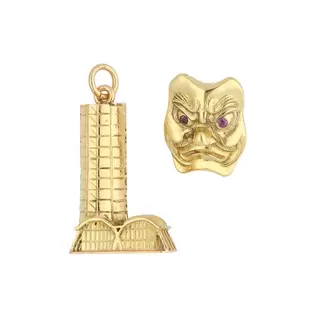 Oferta de Dos dijes diseño especial motivo torre y máscara con sintéticos en oro dos tonos 18 kilates. por $28029 en Nacional Monte de Piedad